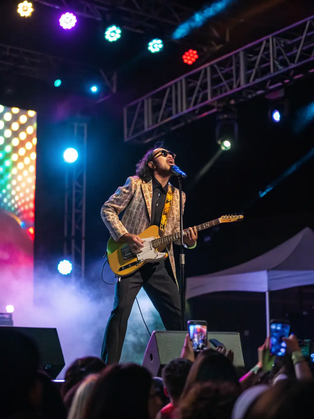A professional musician performing live on stage at a music festival, bathed in colorful stage lights, showcasing a vibrant and energetic performance.